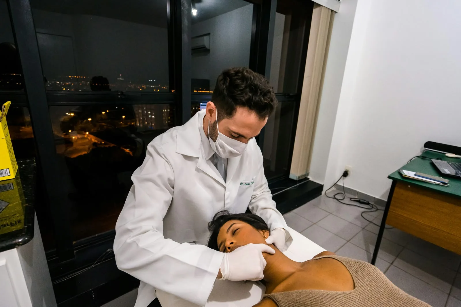 Atendimento no consultório, mãos com luva na região da mandíbula
