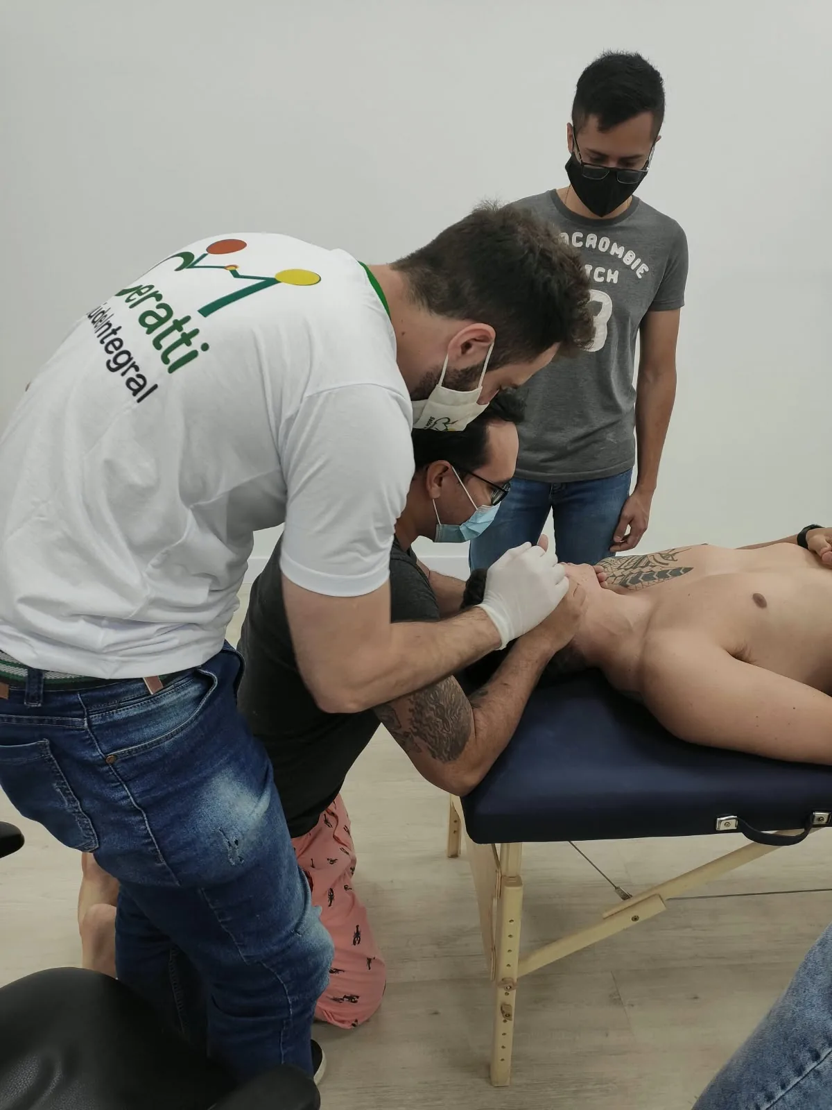 Lucas guiando a mão do aluno sobre o paciente